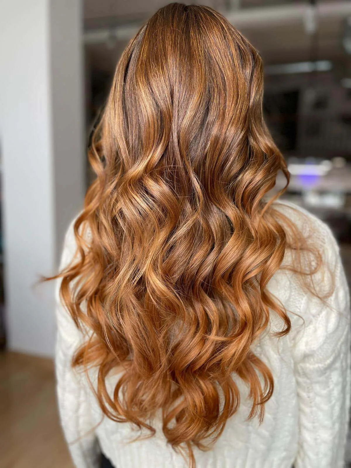 Cabello largo y ondulado, color cálido.